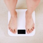 person standing on white digital bathroom scale