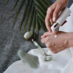 person holding white plastic bottle pouring white liquid on white ceramic mug