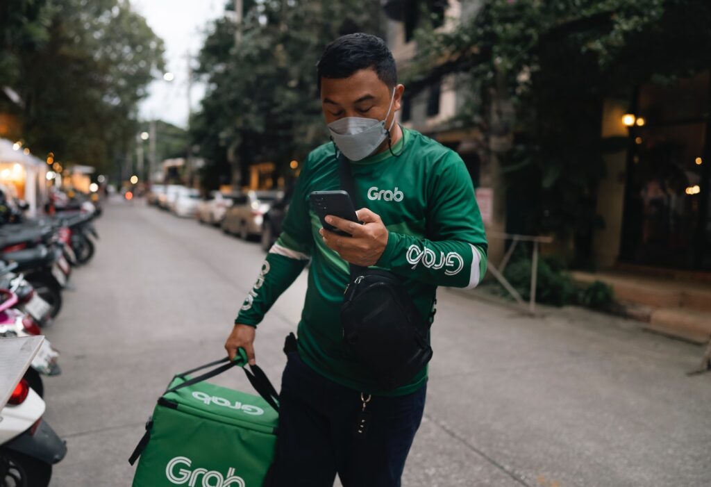 a man wearing a face mask while looking at his cell phone